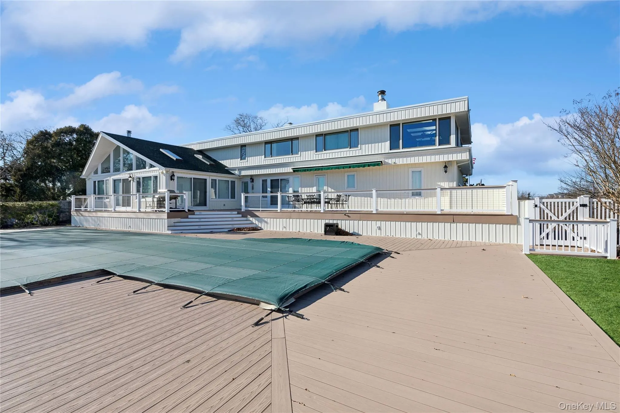 Rear view of house with a pool side deck and a patio area Rear view of house with a pool side deck and a patio area