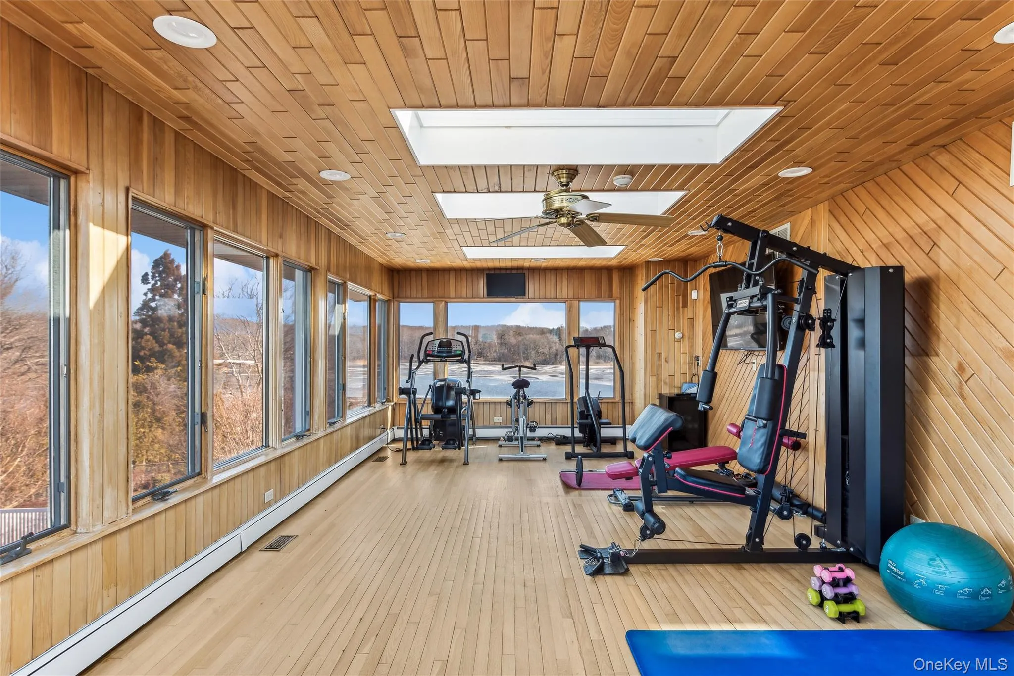 Workout area with hardwood / wood-style flooring, wooden walls, a skylight, and wooden ceiling Workout area with hardwood / wood-style flooring, wooden walls, a skylight, and wooden ceiling