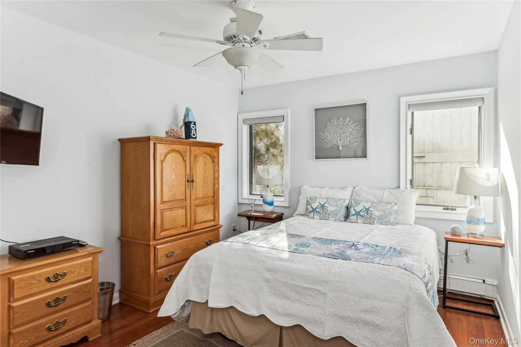 Bedroom featuring dark hardwood / wood-style flooring, a baseboard heating unit, and ceiling fan Bedroom featuring dark hardwood / wood-style flooring, a baseboard heating unit, and ceiling fan
