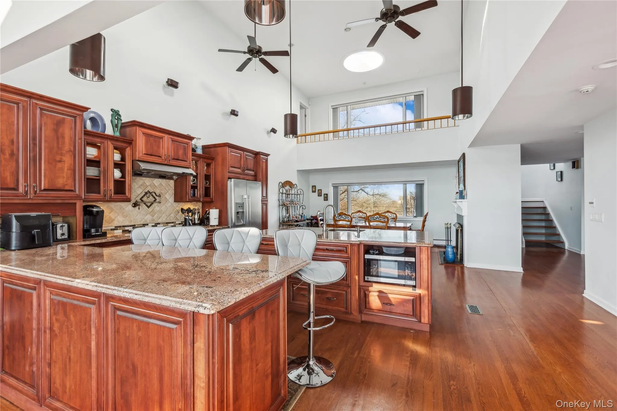 Kitchen featuring sink, a breakfast bar area, ceiling fan, stainless steel appliances, and decorative backsplash Kitchen featuring sink, a breakfast bar area, ceiling fan, stainless steel appliances, and decorative backsplash