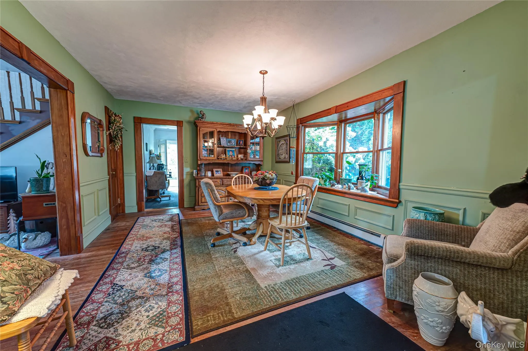 Dining space featuring wood-finish flooring, custom moldings, hardwood floors and an expansive bay window. Dining space featuring wood-finish flooring, custom moldings, hardwood floors and an expansive bay window.