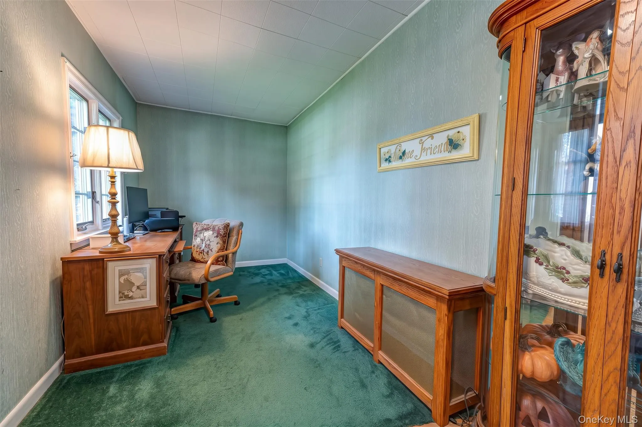 Interior space to left of front entry door featuring a multi-pane window, wall-to-wall carpeting currently used for a home office or could be a nice sitting or play area. Interior space to left of front entry door featuring a multi-pane window, wall-to-wall carpeting currently used for a home office or could be a nice sitting or play area.