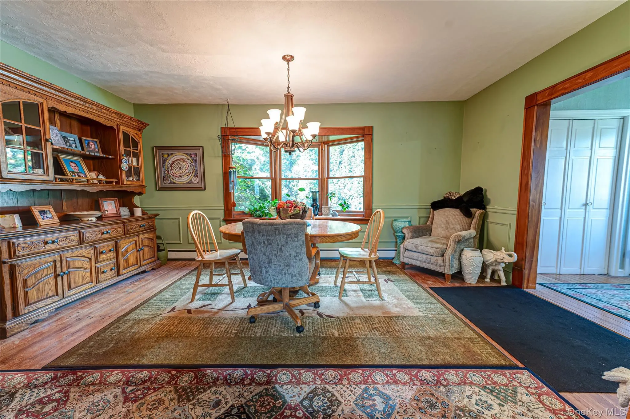 Dining area featuring a bay window with natural wood trim, custom moldings and hardwood floors. Dining area featuring a bay window with natural wood trim, custom moldings and hardwood floors.