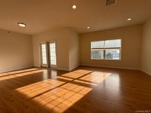 Empty room with healthy amount of natural light, recessed lighting, and hardwood / wood-style floors Empty room with healthy amount of natural light, recessed lighting, and hardwood / wood-style floors