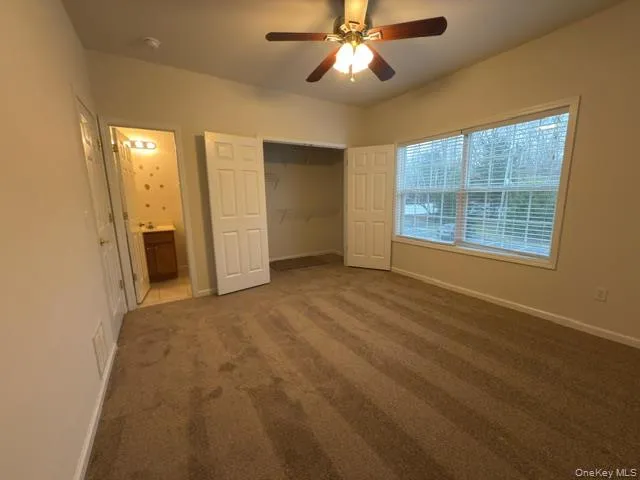 Unfurnished bedroom featuring a ceiling fan, carpet flooring, a closet, and ensuite bathroom Unfurnished bedroom featuring a ceiling fan, carpet flooring, a closet, and ensuite bathroom
