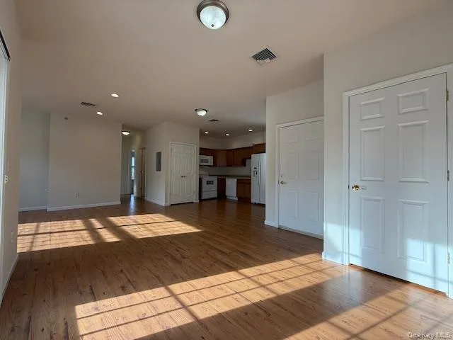Unfurnished living room with dark wood-style floors and recessed lighting Unfurnished living room with dark wood-style floors and recessed lighting