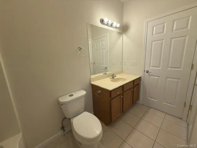 Full bath featuring vanity and light tile patterned floors Full bath featuring vanity and light tile patterned floors
