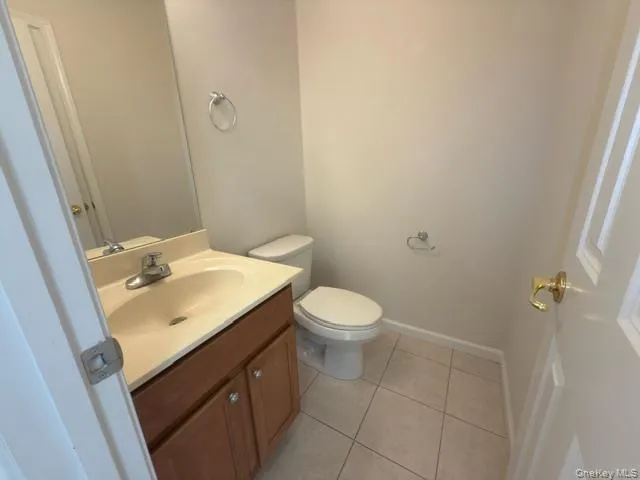 Half bath featuring vanity and light tile patterned floors Half bath featuring vanity and light tile patterned floors