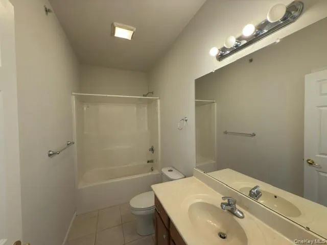 Full bathroom featuring light tile patterned floors, shower / bathtub combination, and vanity Full bathroom featuring light tile patterned floors, shower / bathtub combination, and vanity