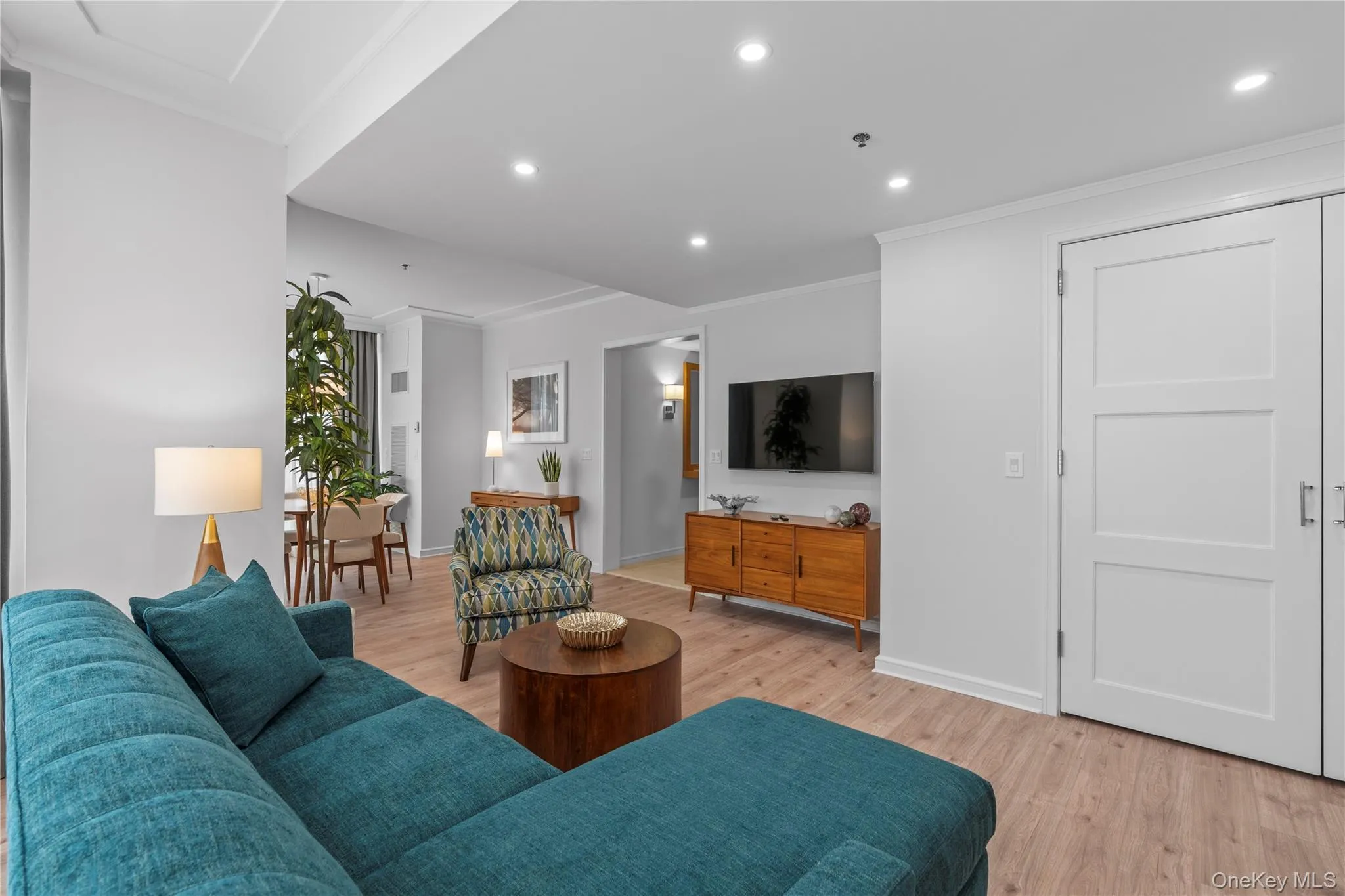 Living area with light wood-style flooring, ornamental molding, baseboards, and recessed lighting Living area with light wood-style flooring, ornamental molding, baseboards, and recessed lighting