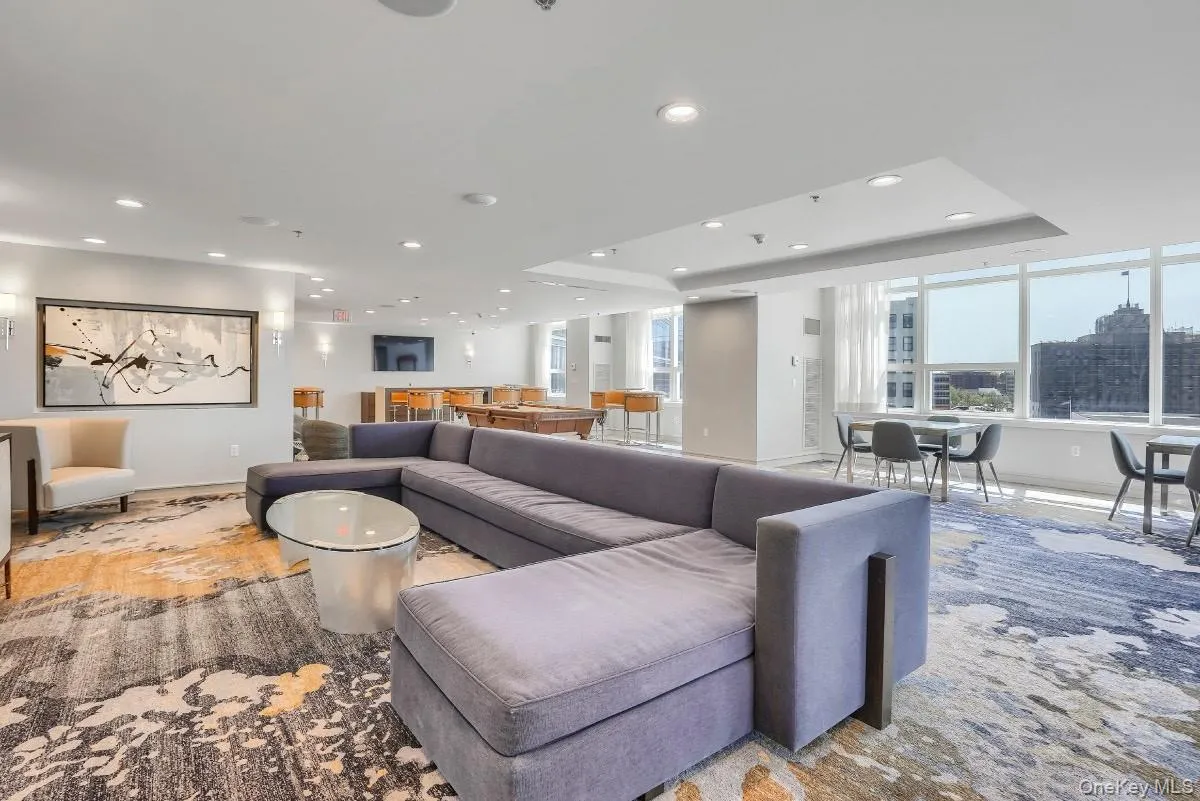 Living room featuring recessed lighting, baseboards, and a raised ceiling Living room featuring recessed lighting, baseboards, and a raised ceiling