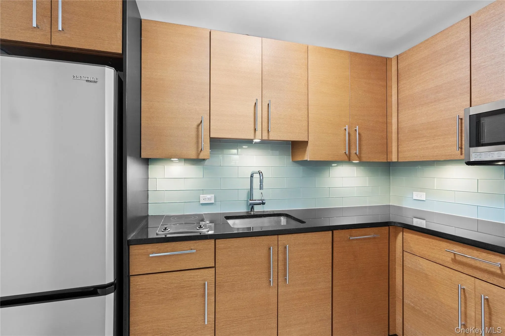 Kitchen featuring appliances with stainless steel finishes, a sink, and backsplash Kitchen featuring appliances with stainless steel finishes, a sink, and backsplash