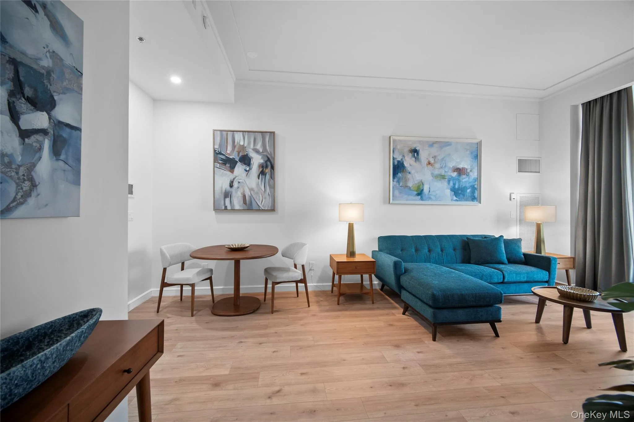 Living room featuring light wood finished floors, crown molding, baseboards, and recessed lighting Living room featuring light wood finished floors, crown molding, baseboards, and recessed lighting
