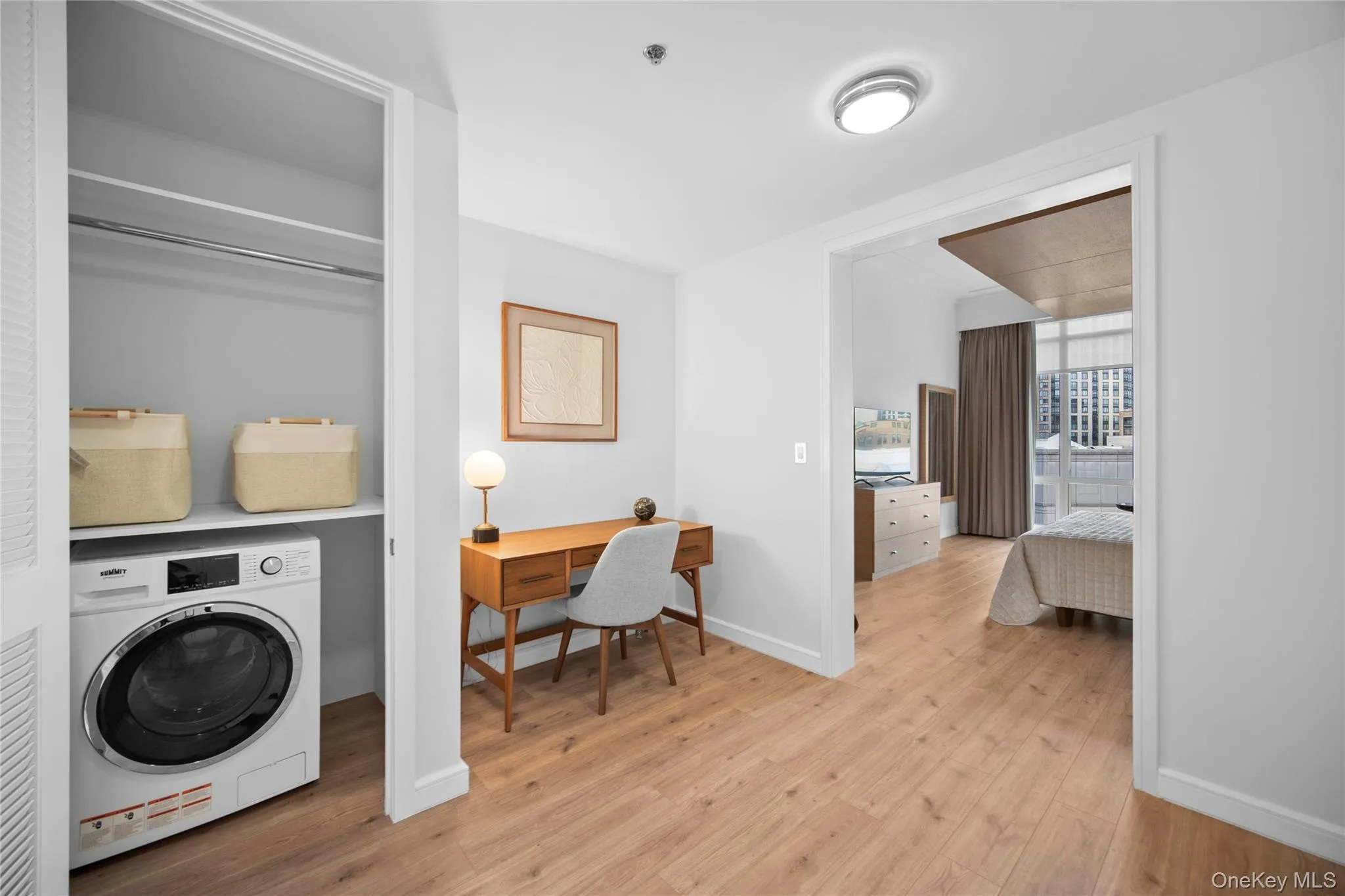 Washroom with washer / clothes dryer, light wood-style floors, and baseboards Washroom with washer / clothes dryer, light wood-style floors, and baseboards
