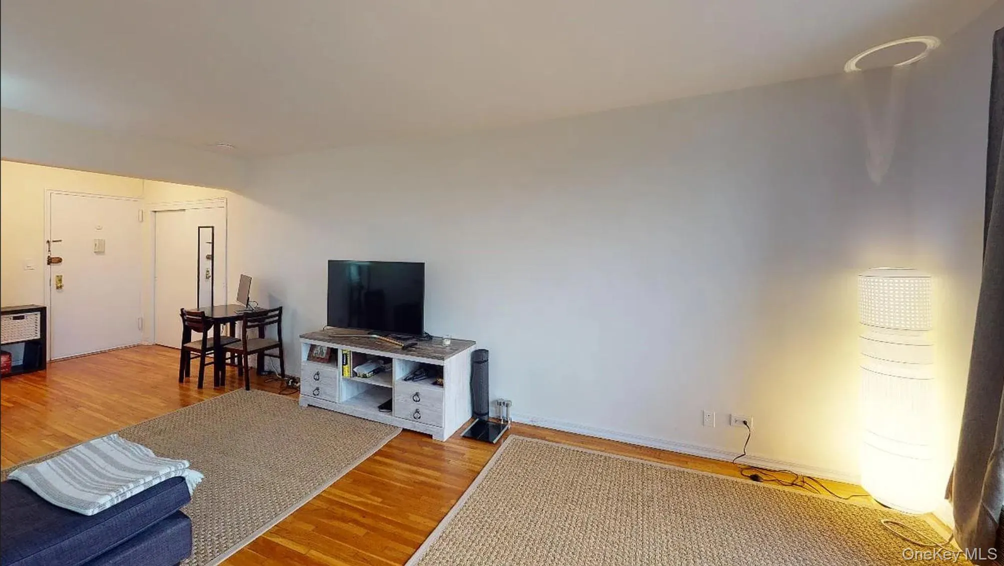Open-concept interior featuring light-toned walls and polished wood-finish flooring Open-concept interior featuring light-toned walls and polished wood-finish flooring