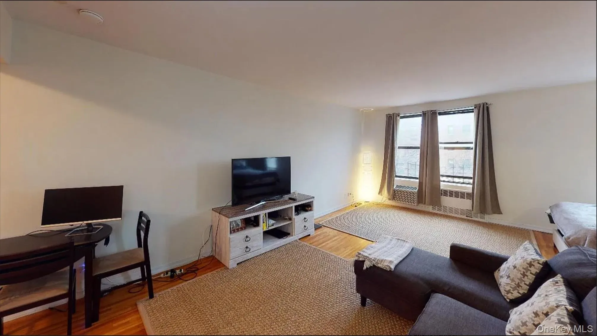 Open-concept interior space featuring hardwood flooring and expansive windows Open-concept interior space featuring hardwood flooring and expansive windows