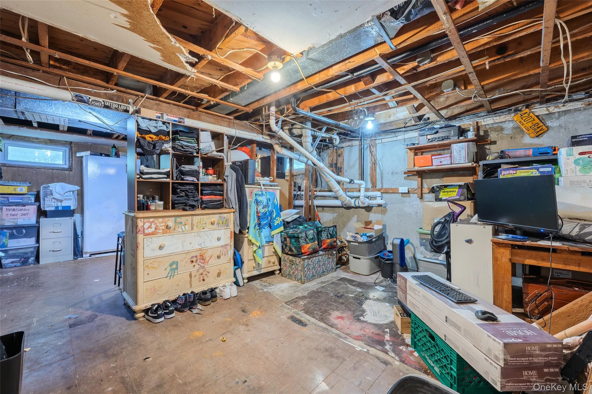 Unfinished basement area featuring exposed ceiling joists, concrete foundation walls, and a single-pane window Unfinished basement area featuring exposed ceiling joists, concrete foundation walls, and a single-pane window