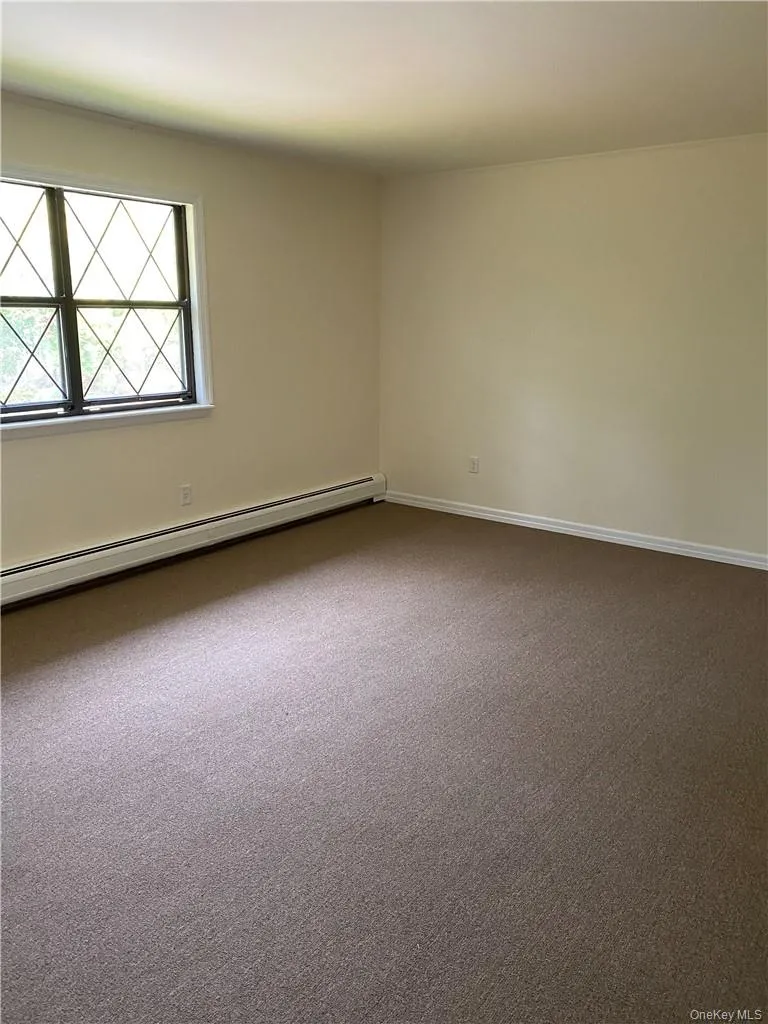 room with baseboard heating and carpet flooring room with baseboard heating and carpet flooring
