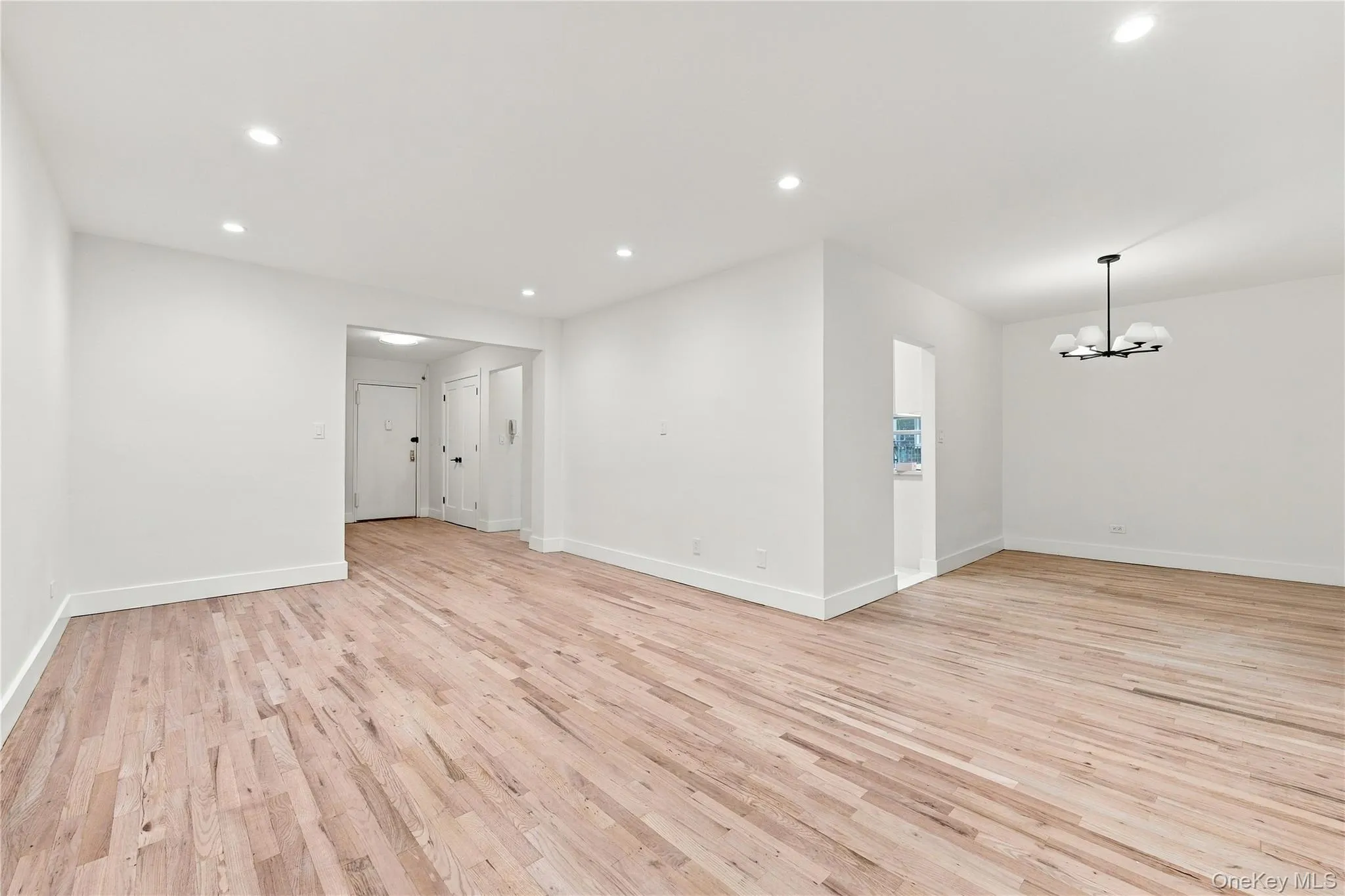 Interior space featuring light wood-finish flooring, recessed lighting, and a multi-globe chandelier Interior space featuring light wood-finish flooring, recessed lighting, and a multi-globe chandelier