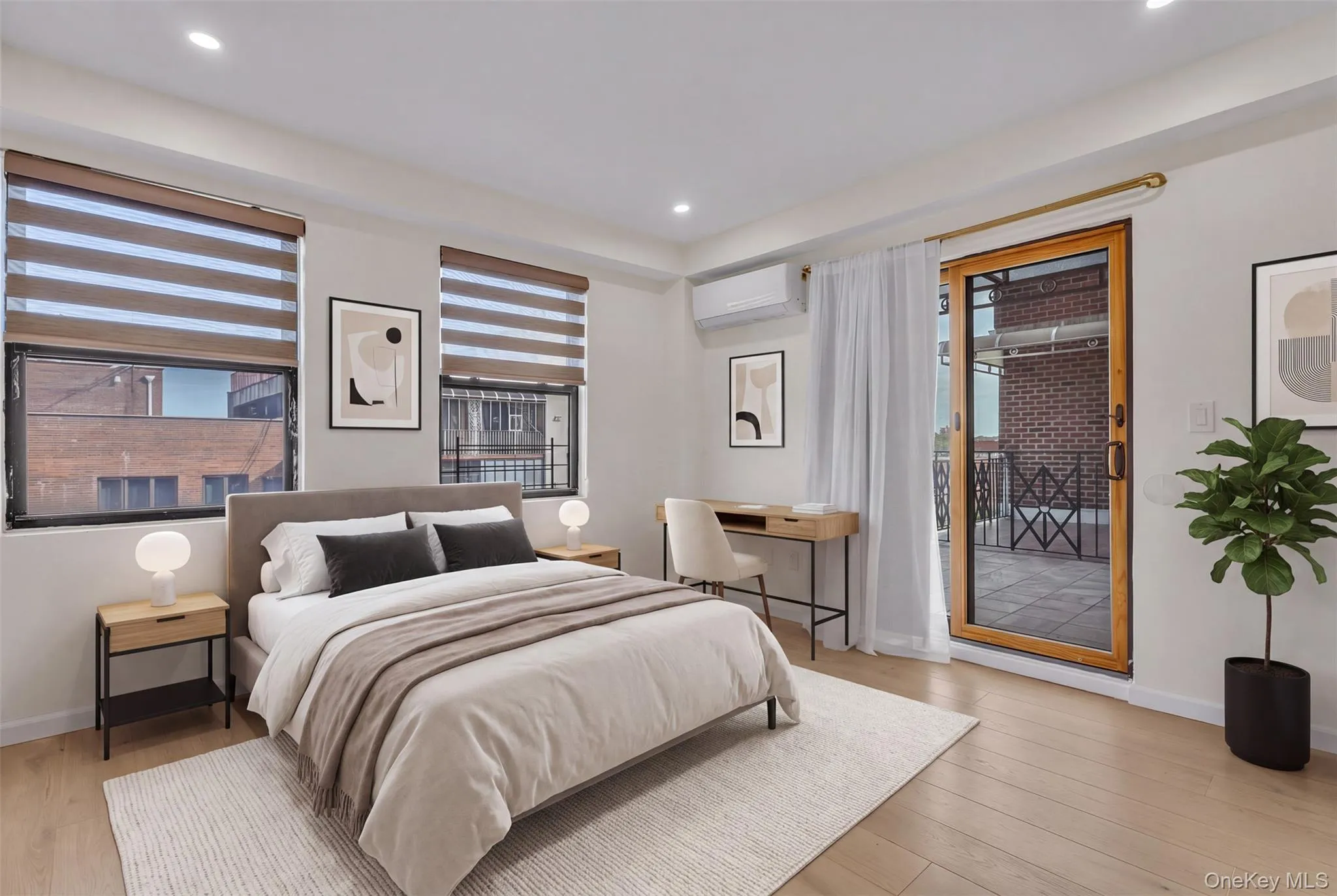 Wood-finish flooring, recessed lighting, dual-pane windows with integrated blinds, wall-mounted ductless climate control system, and a sliding glass door providing access to a private balcony Wood-finish flooring, recessed lighting, dual-pane windows with integrated blinds, wall-mounted ductless climate control system, and a sliding glass door providing access to a private balcony