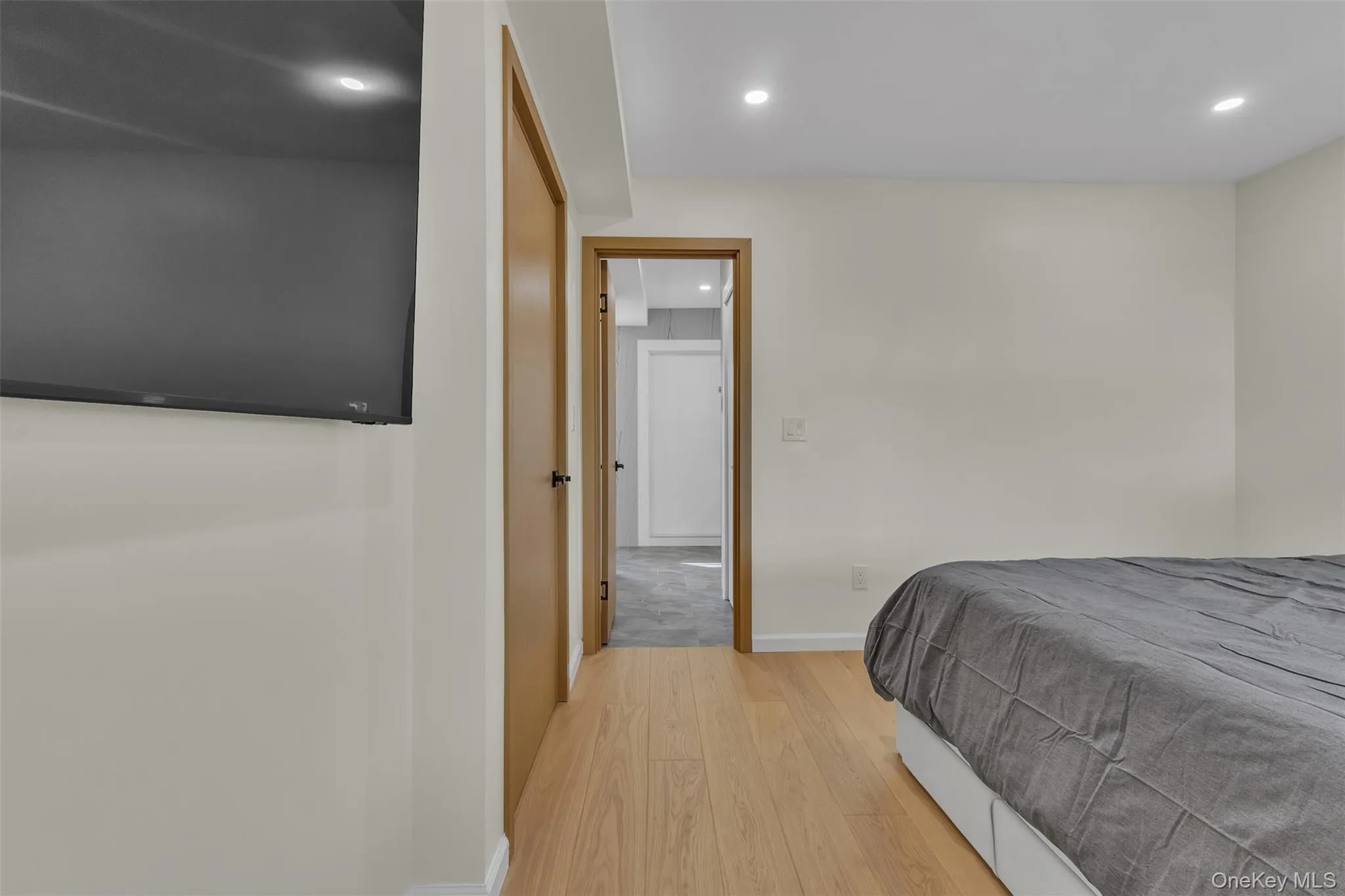 Light-toned wood-finish flooring, recessed ceiling lighting, and solid-core wood-finish doors Light-toned wood-finish flooring, recessed ceiling lighting, and solid-core wood-finish doors