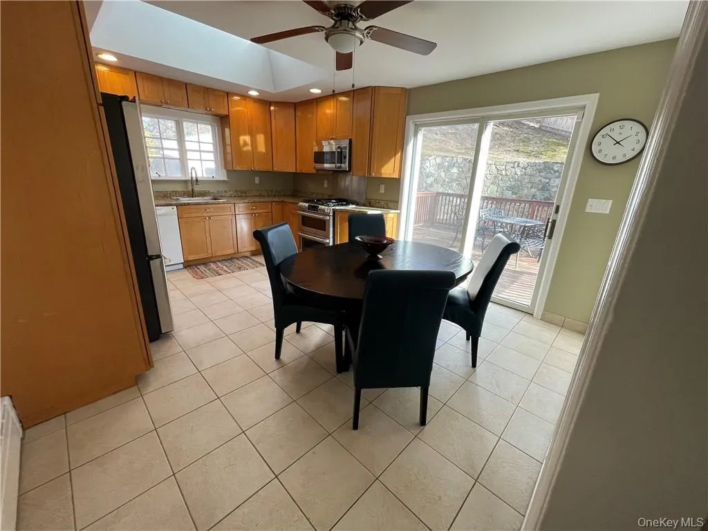 Dining space featuring ceiling fan, light tile patterned floors, and sink Dining space featuring ceiling fan, light tile patterned floors, and sink