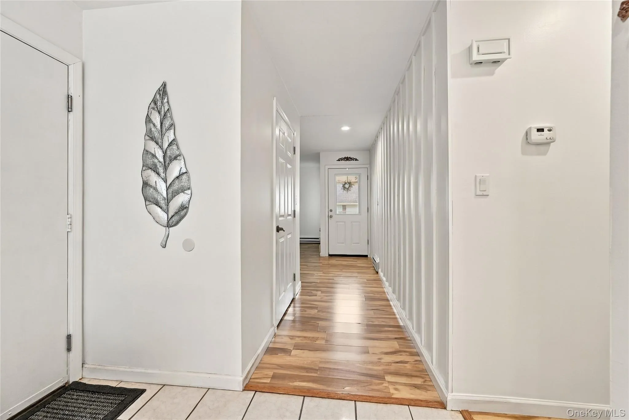 The Entry & Hallway Offers Crisp White Walls & Modern Decor, Stunning Board & Batten/Wainscoted Walls, Recessed Lighting & Laminate Flooring. The Entry & Hallway Offers Crisp White Walls & Modern Decor, Stunning Board & Batten/Wainscoted Walls, Recessed Lighting & Laminate Flooring.