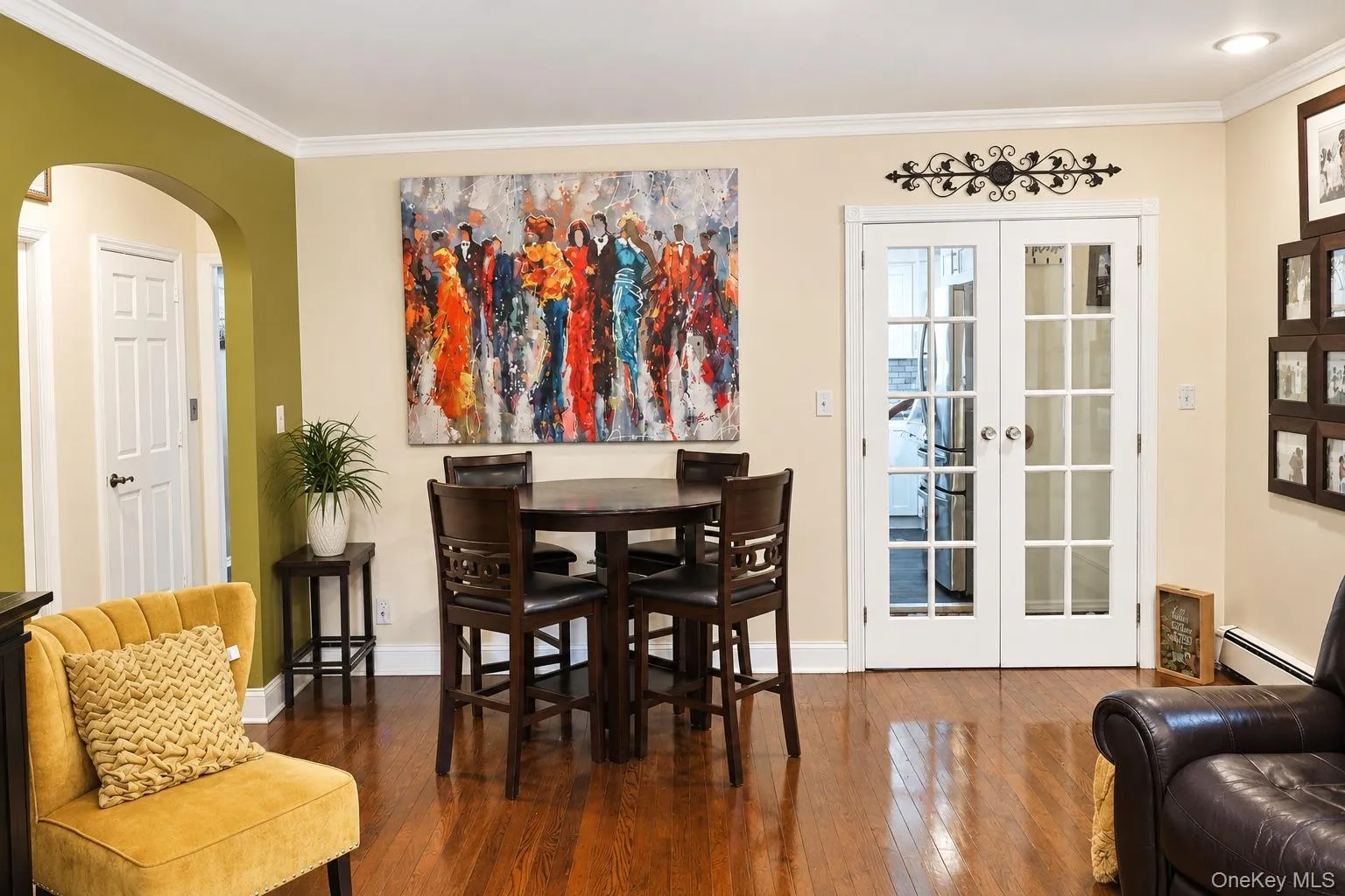 Wood-finish flooring, architectural arched opening, and glass-paned double French doors with white casing Wood-finish flooring, architectural arched opening, and glass-paned double French doors with white casing