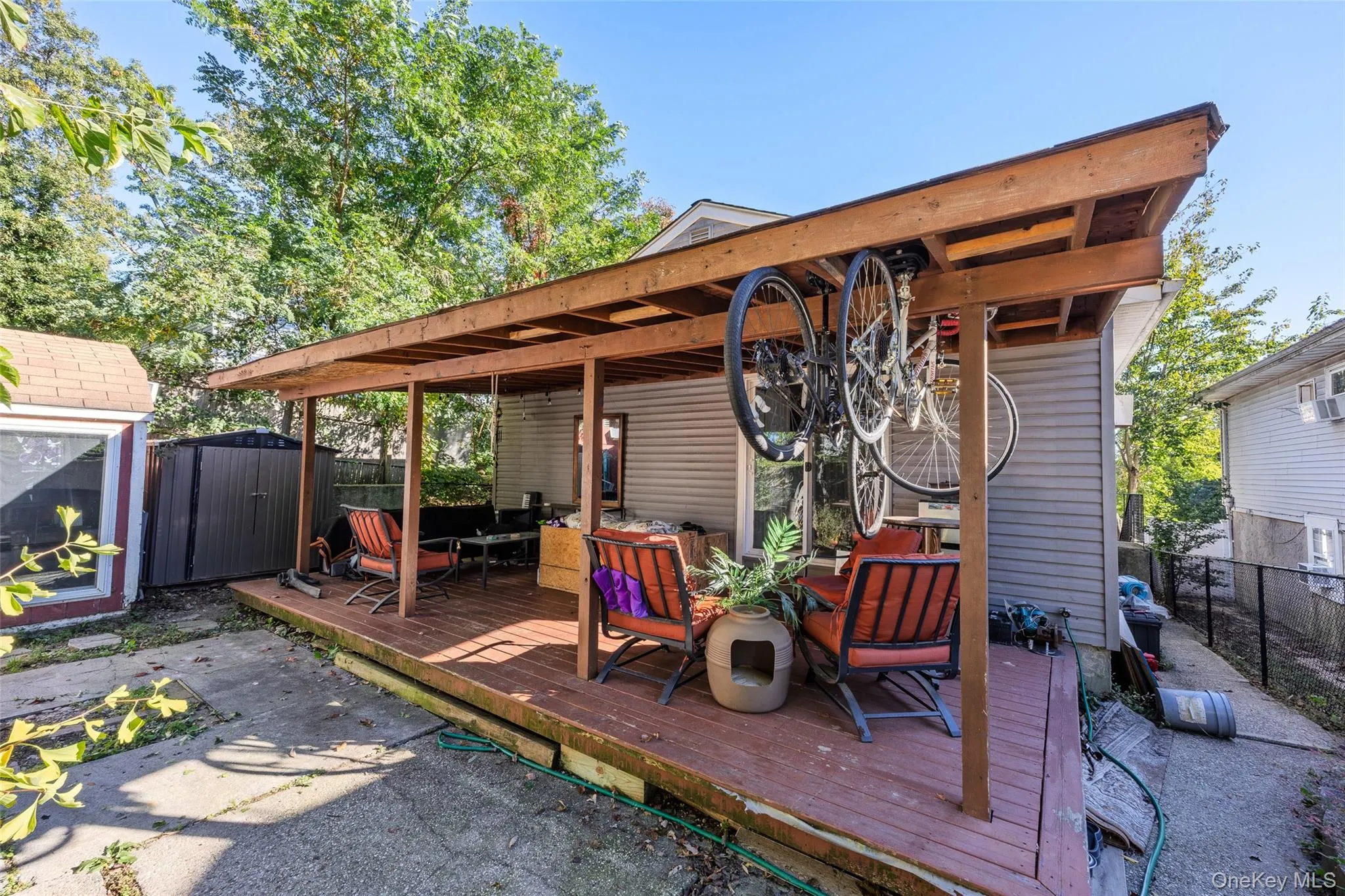 Covered rear deck featuring wood-plank flooring, support beams, and exposed rafters Covered rear deck featuring wood-plank flooring, support beams, and exposed rafters