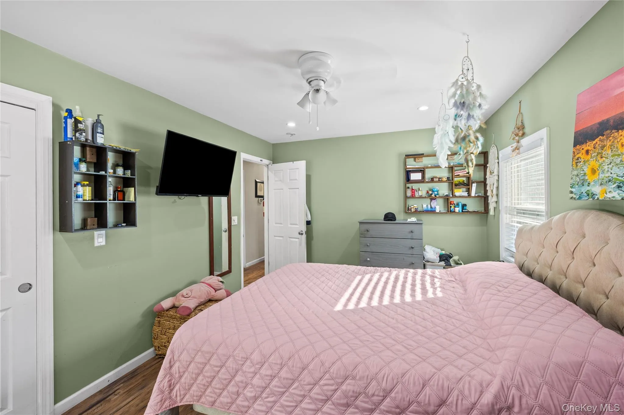 Interior space featuring wood-finish flooring, recessed lighting, a white ceiling fan, and built-in wall shelving Interior space featuring wood-finish flooring, recessed lighting, a white ceiling fan, and built-in wall shelving