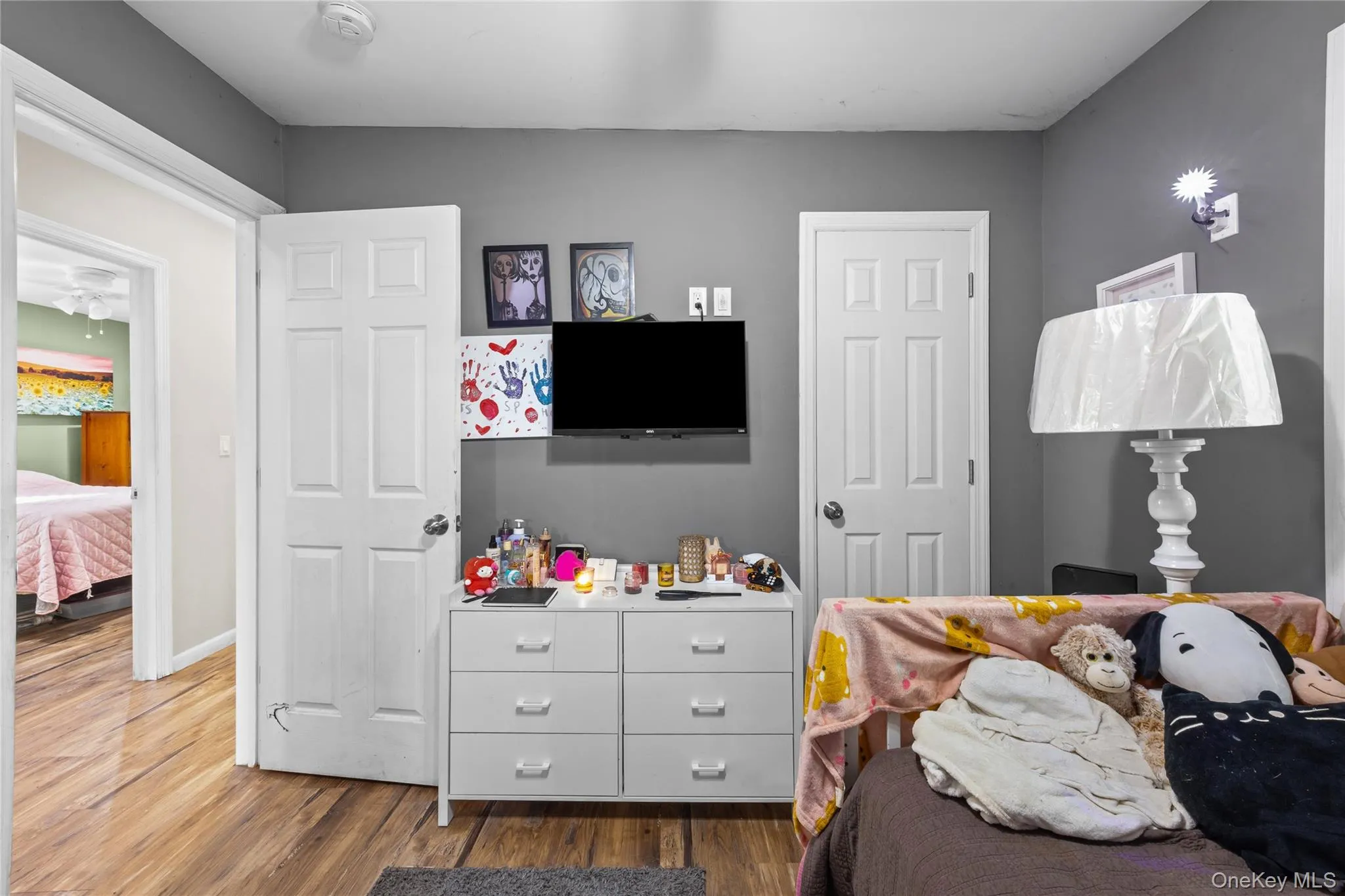 Wood-finish flooring, two six-panel interior doors, and wall-mounted lighting fixture Wood-finish flooring, two six-panel interior doors, and wall-mounted lighting fixture