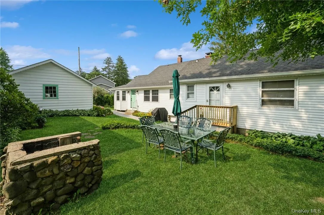 Rear view of property featuring a deck and a yard Rear view of property featuring a deck and a yard