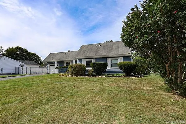 View of front facade featuring a front lawn and an attached garage View of front facade featuring a front lawn and an attached garage
