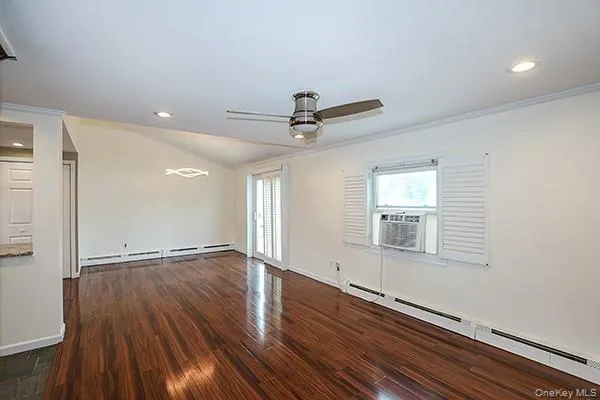 Spare room featuring baseboard heating, dark wood finished floors, recessed lighting, ornamental molding, and ceiling fan Spare room featuring baseboard heating, dark wood finished floors, recessed lighting, ornamental molding, and ceiling fan