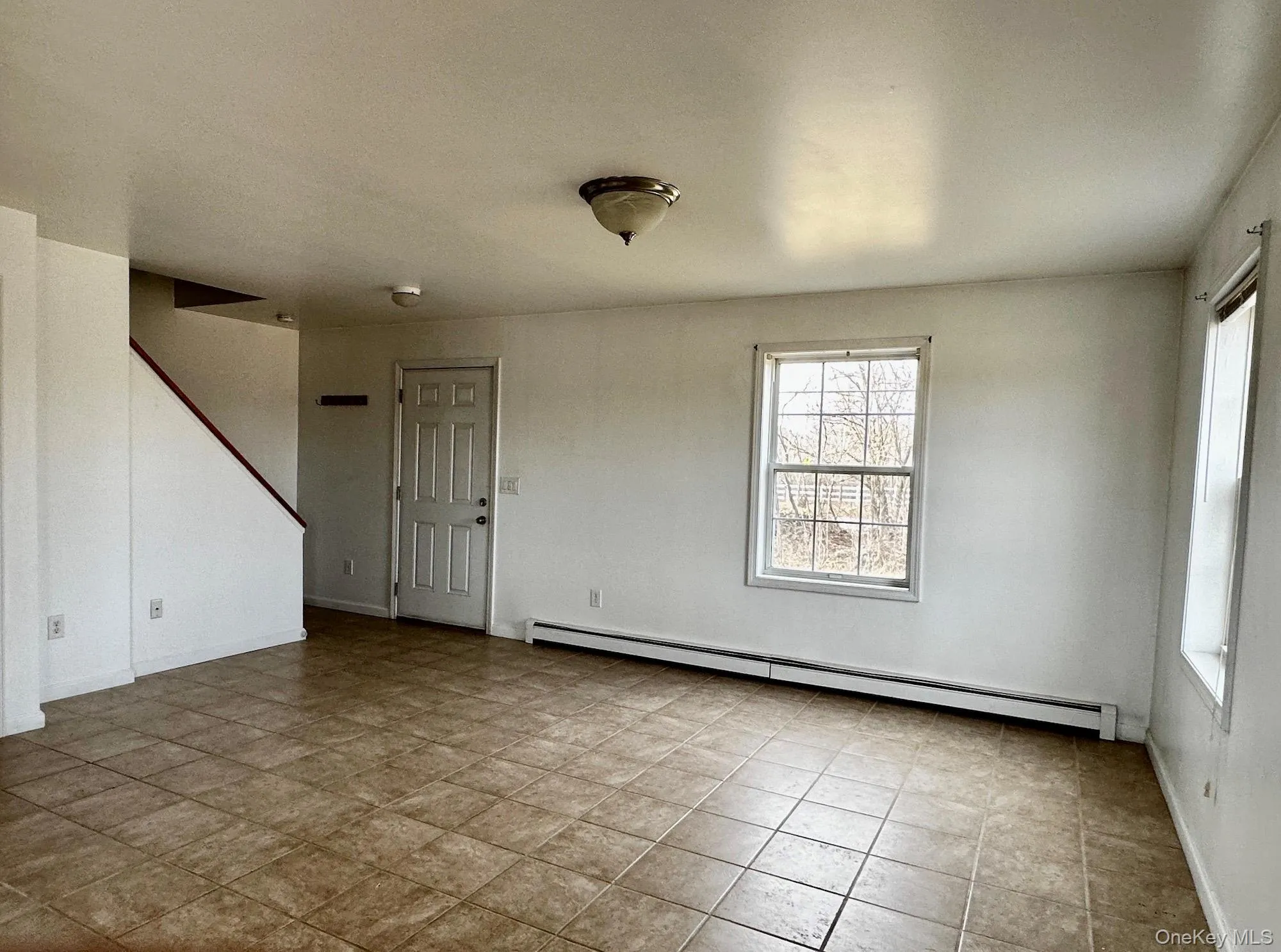 Unfurnished room with baseboard heating and tile patterned flooring Unfurnished room with baseboard heating and tile patterned flooring