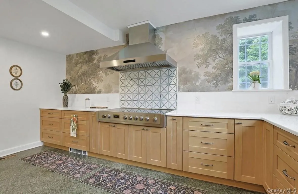 Kitchen featuring light-tone wood cabinetry, white stone countertops, stainless steel professional-grade rang Kitchen featuring light-tone wood cabinetry, white stone countertops, stainless steel professional-grade rang