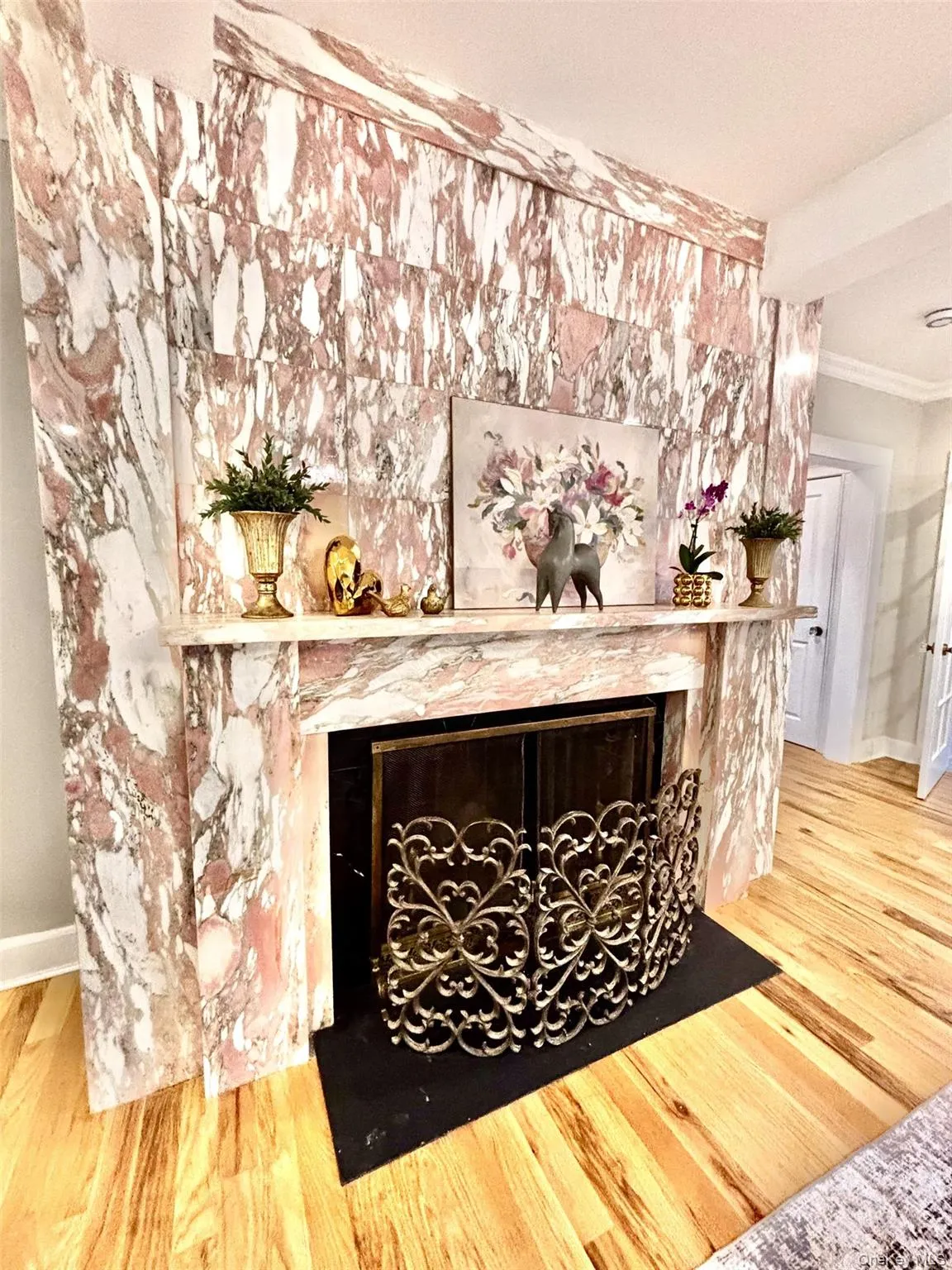 Floor-to-ceiling pink marble fireplace surround featuring a prominent mantel Floor-to-ceiling pink marble fireplace surround featuring a prominent mantel