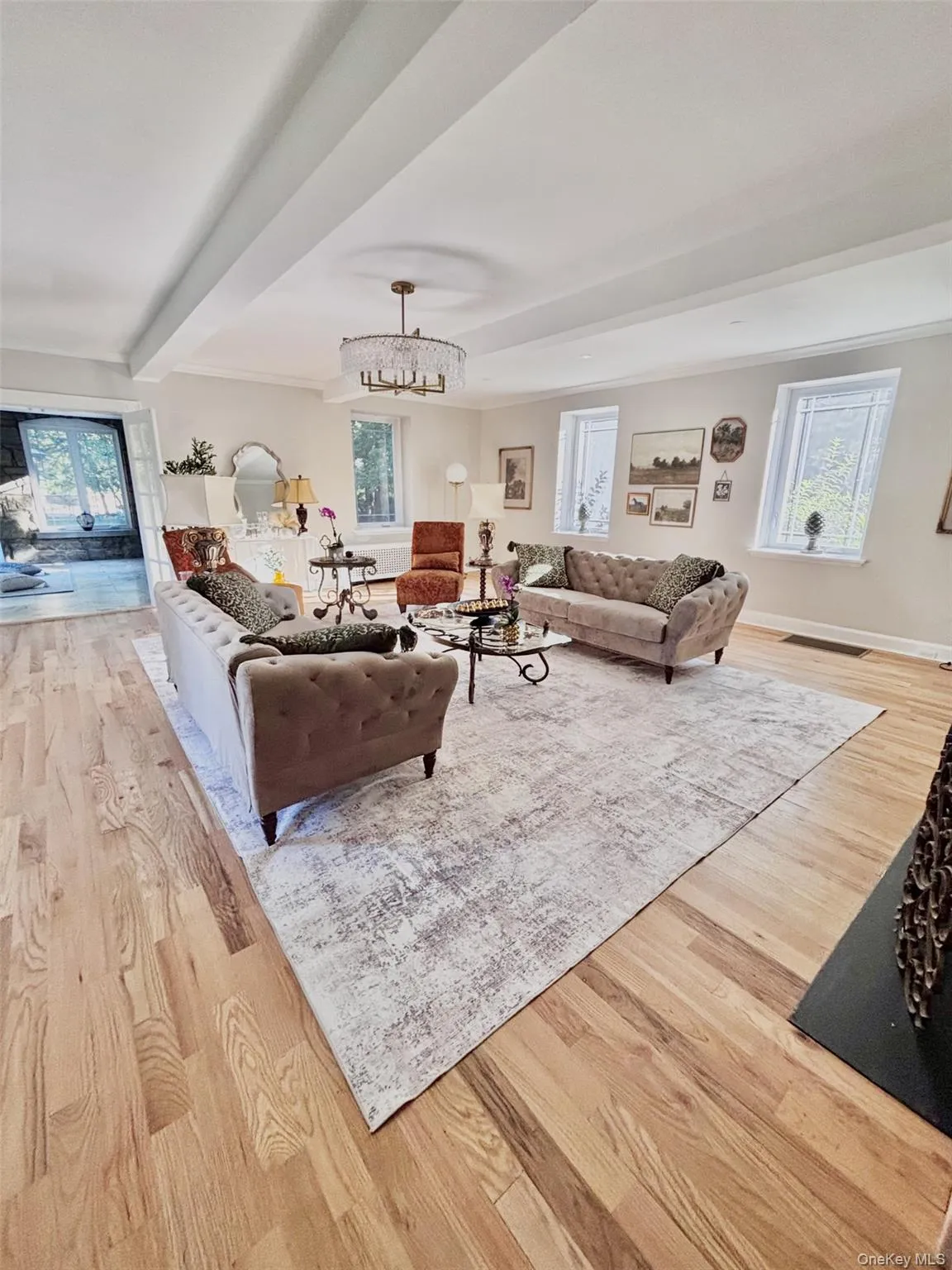 Light-filled living area recessed ceiling detailing, , and a tiered crystal chandelier Light-filled living area recessed ceiling detailing, , and a tiered crystal chandelier