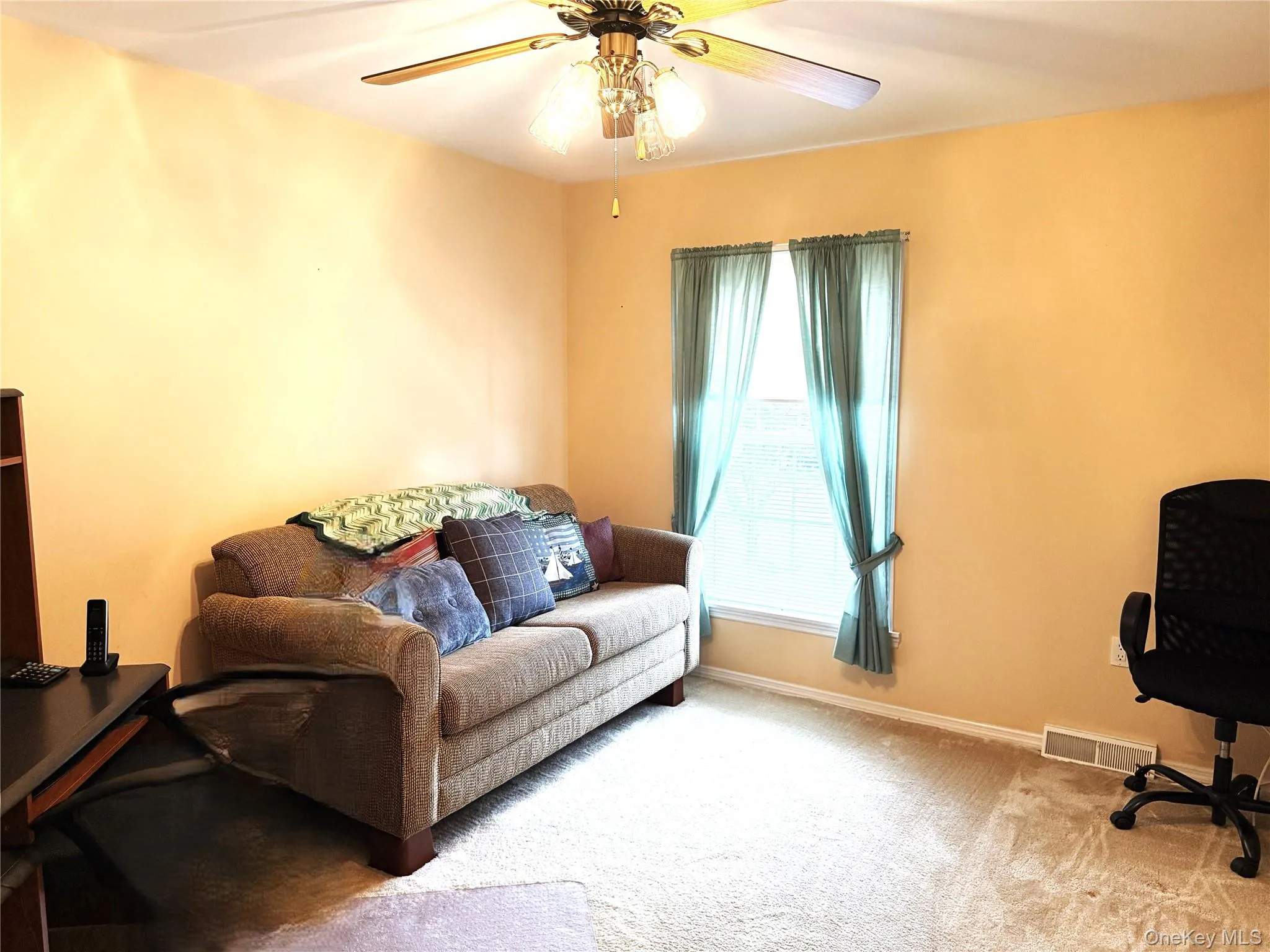 Room featuring wall-to-wall carpeting, a multi-light ceiling fan, and a window with natural lighting. Room featuring wall-to-wall carpeting, a multi-light ceiling fan, and a window with natural lighting.