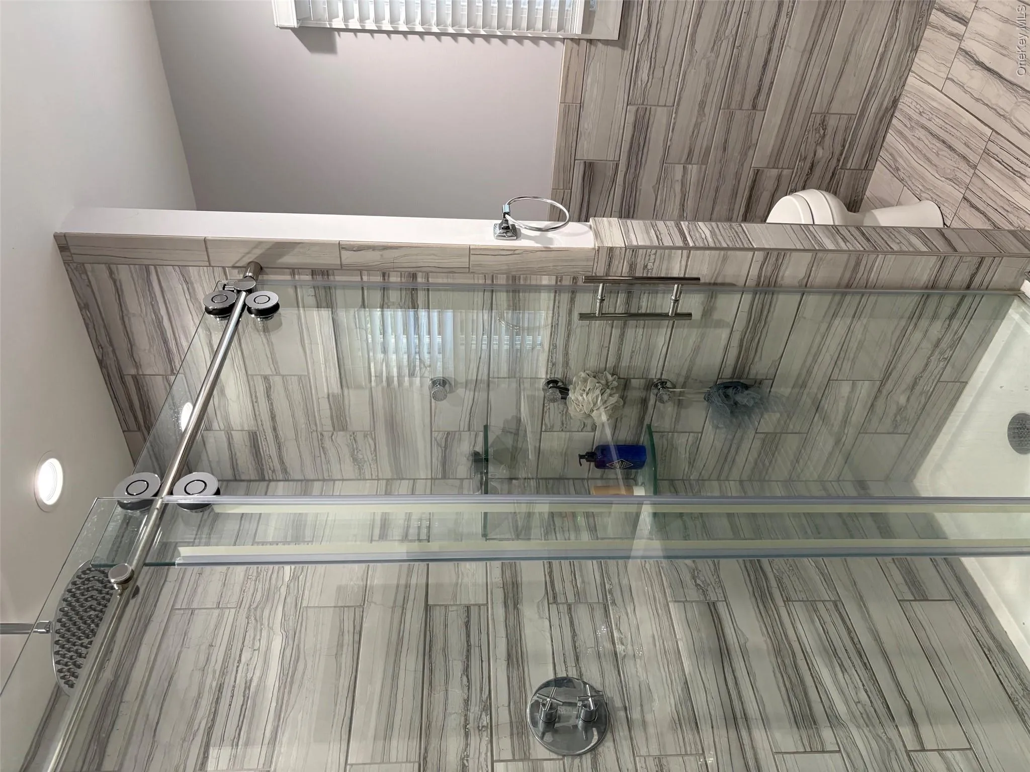Updated bathroom with waterfall shower head and a window Updated bathroom with waterfall shower head and a window