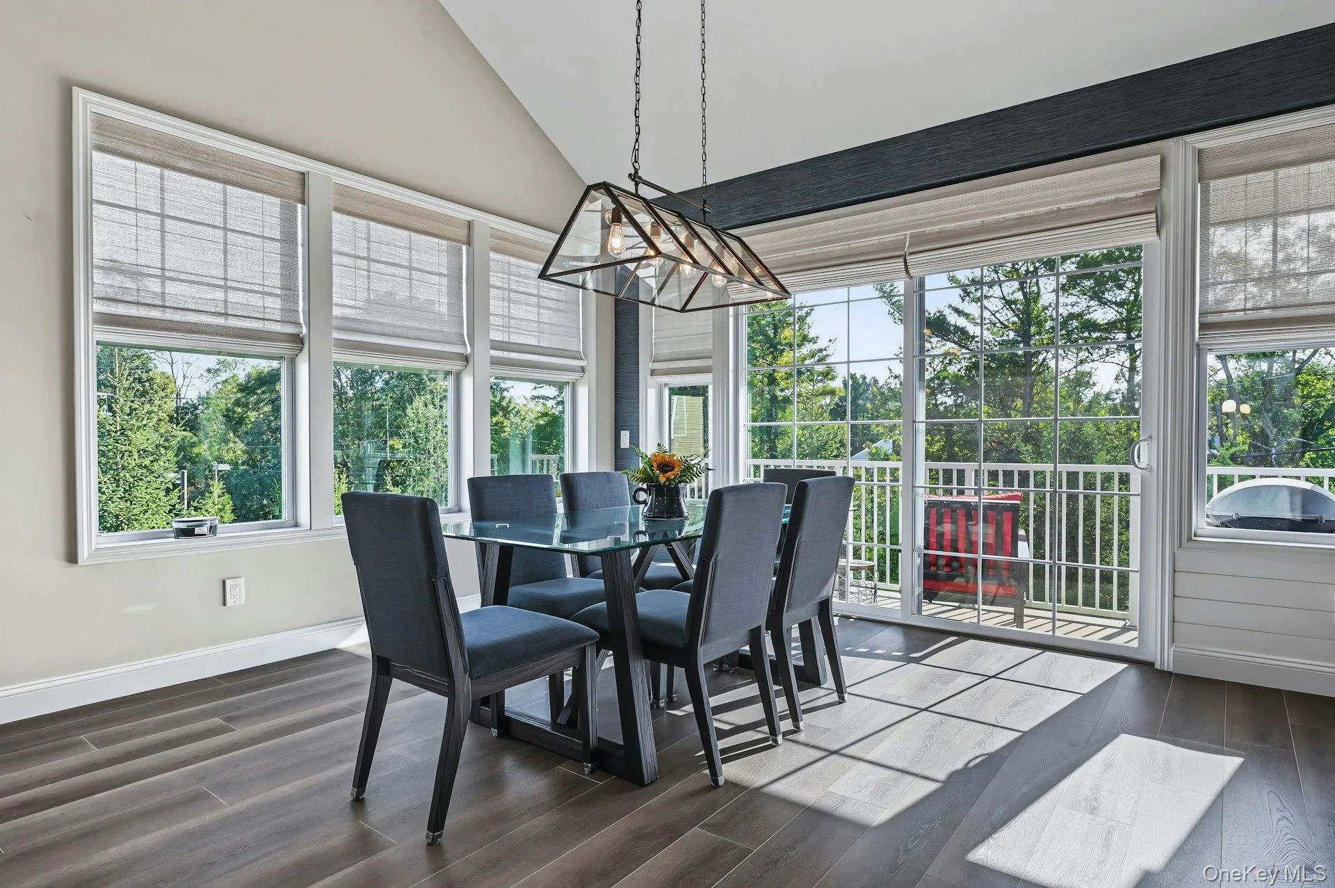 Dining area with vaulted ceiling, surrounded by windows and doors to the deck. Dining area with vaulted ceiling, surrounded by windows and doors to the deck.