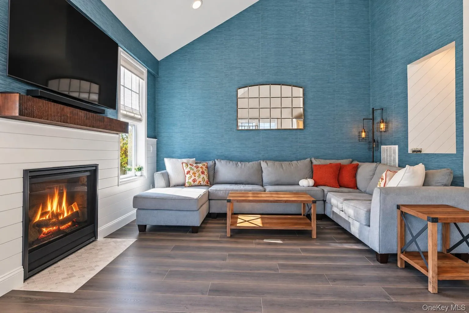 Vaulted ceilings, fireplace with a wood mantel, horizontal shiplap wall detail, textured wall coverings Vaulted ceilings, fireplace with a wood mantel, horizontal shiplap wall detail, textured wall coverings