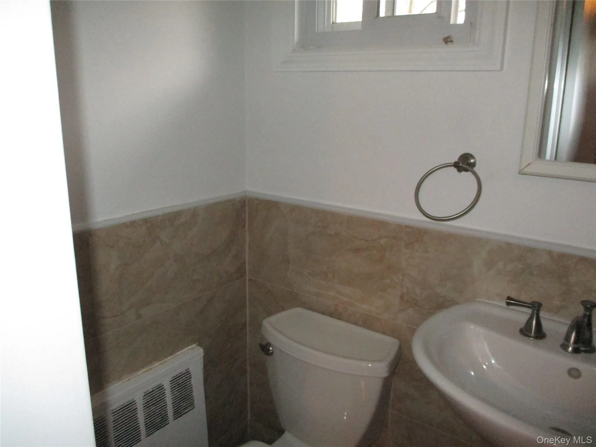 Bathroom featuring wainscoting, tile walls, and radiator Bathroom featuring wainscoting, tile walls, and radiator