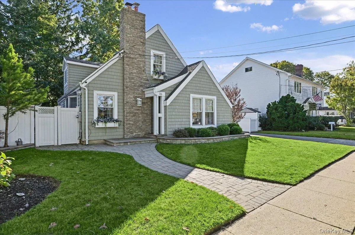 Exterior facade featuring shake siding, a stone chimney, paver walkway, and built-in window boxes Exterior facade featuring shake siding, a stone chimney, paver walkway, and built-in window boxes