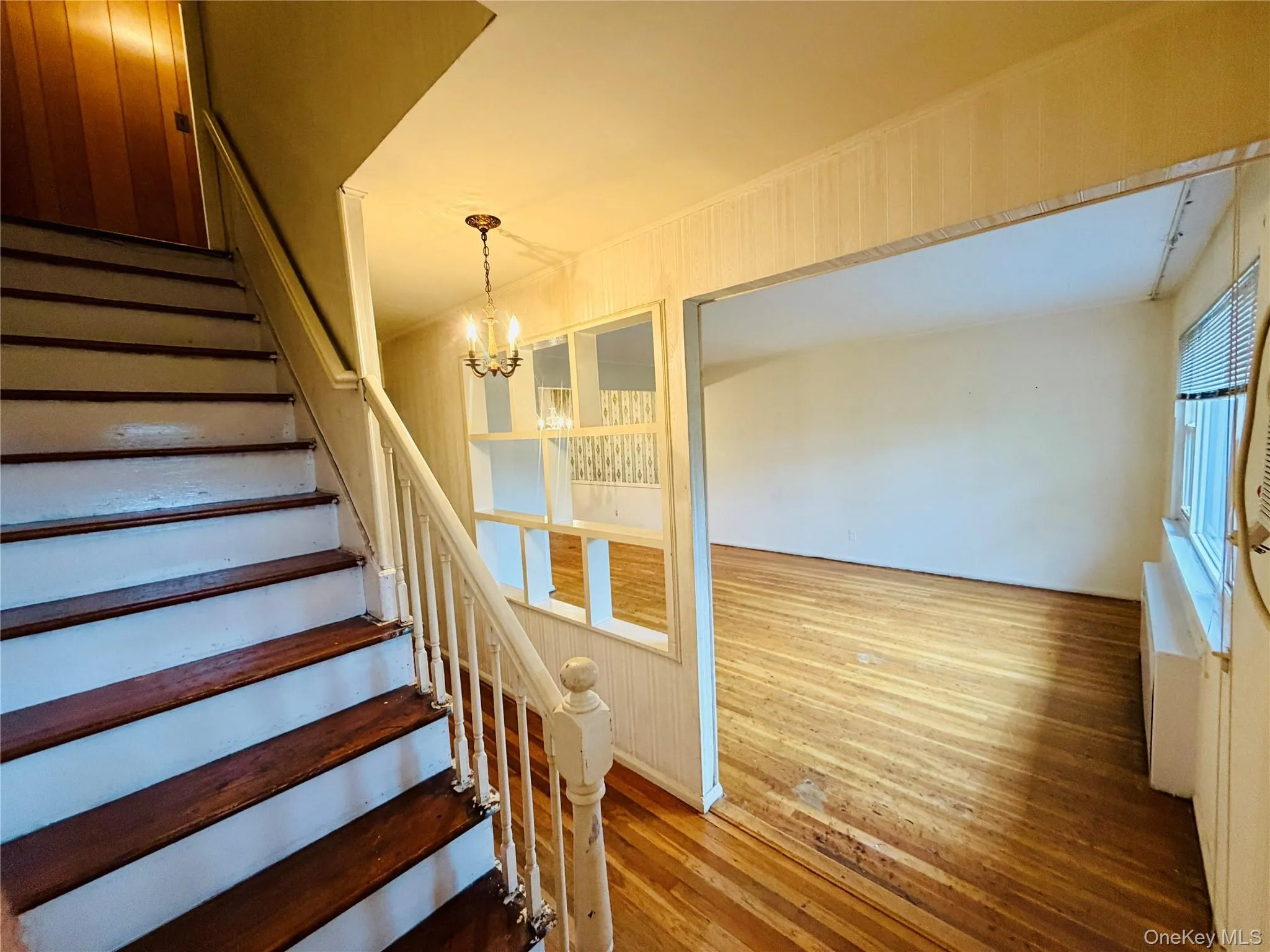 View Of Living Room from Entry Hall, featuring Hardwood floors and Stairs to Second Level Leading to a full bath and two Bedrooms. View Of Living Room from Entry Hall, featuring Hardwood floors and Stairs to Second Level Leading to a full bath and two Bedrooms.
