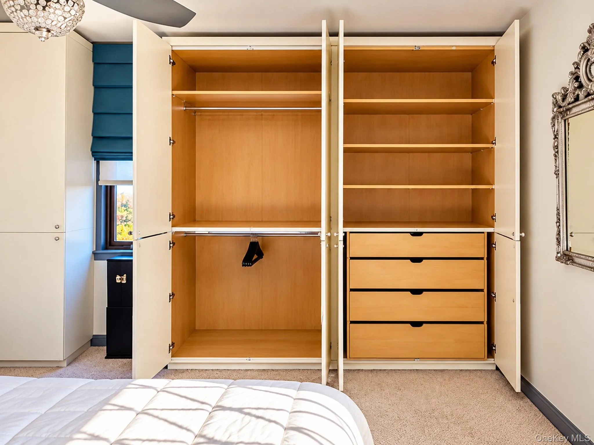 Custom floor-to-ceiling built-in cabinetry featuring wood-finish interior shelving, hanging rods, and a bank of integrated storage drawers Custom floor-to-ceiling built-in cabinetry featuring wood-finish interior shelving, hanging rods, and a bank of integrated storage drawers