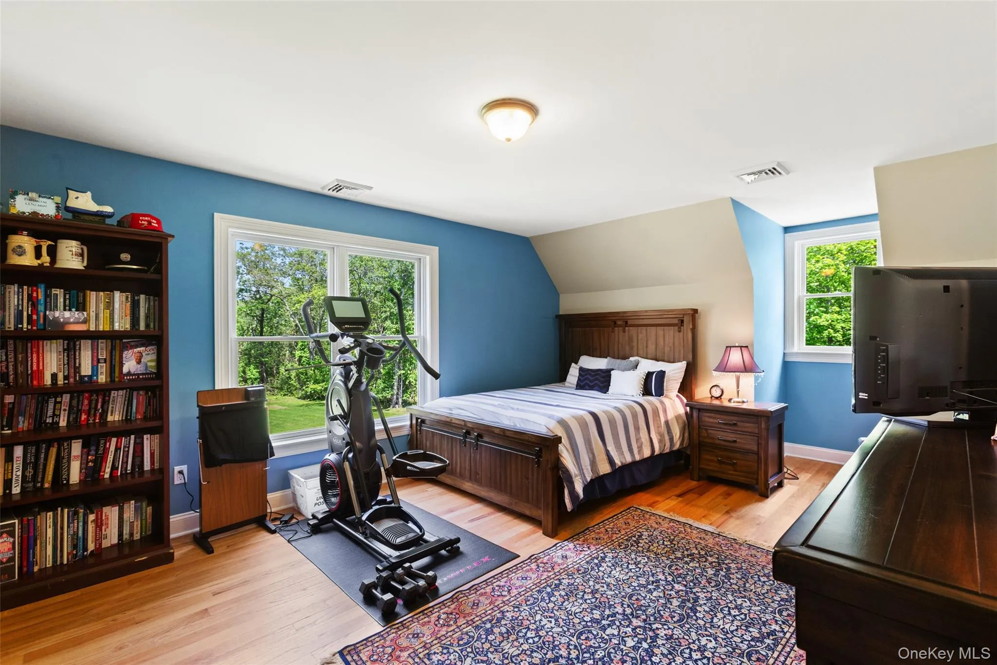 Bedroom featuring wood finished floors, baseboards, and vaulted ceiling Bedroom featuring wood finished floors, baseboards, and vaulted ceiling
