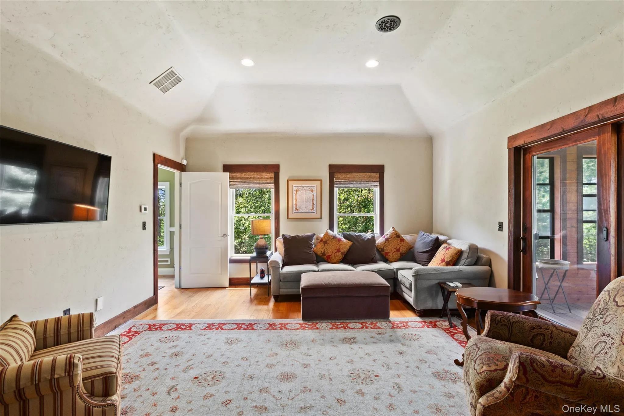 Living area with light wood-style floors and vaulted ceiling Living area with light wood-style floors and vaulted ceiling
