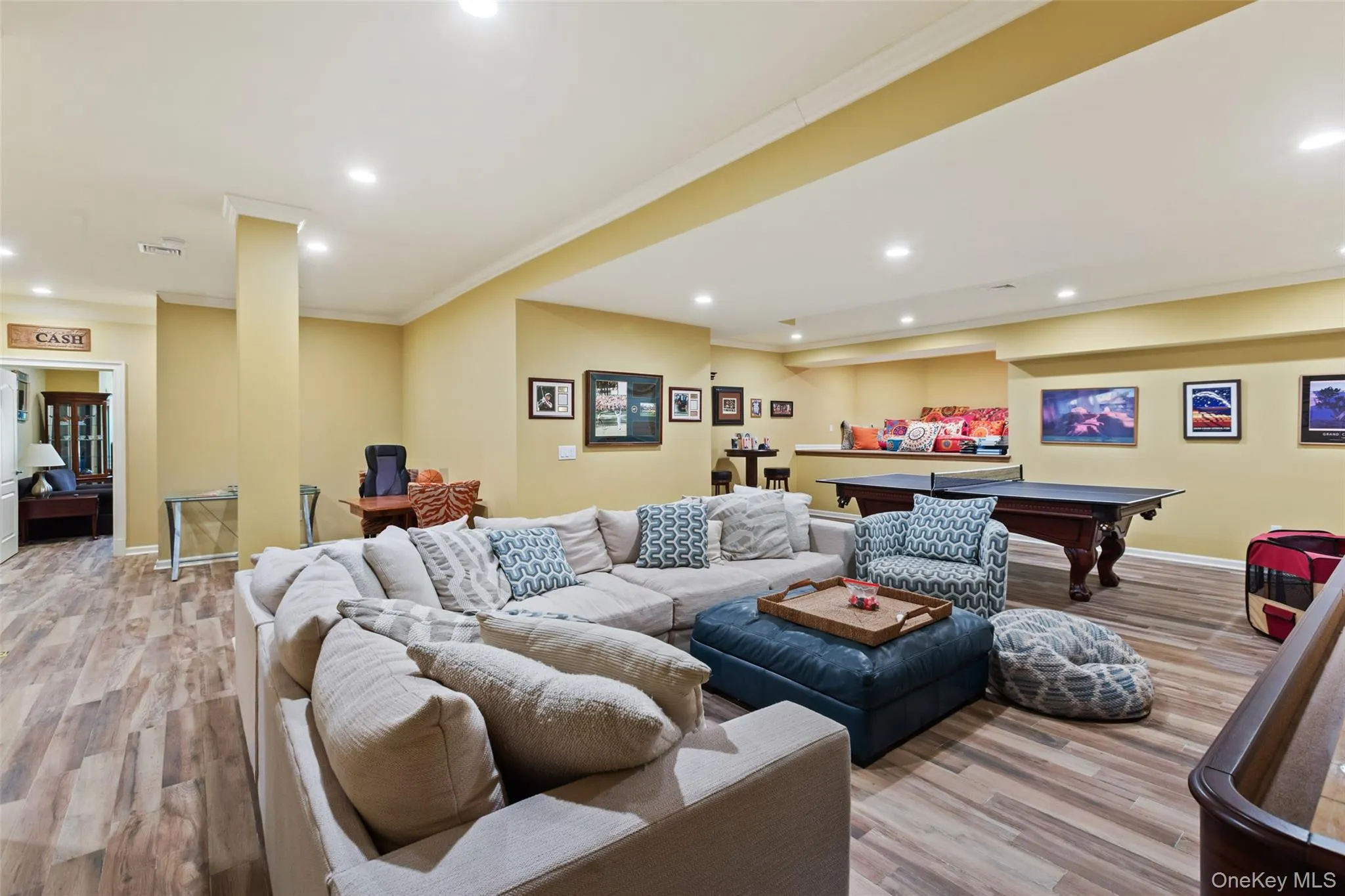 Living room featuring billiards, crown molding, recessed lighting, wood finished floors, and baseboards Living room featuring billiards, crown molding, recessed lighting, wood finished floors, and baseboards