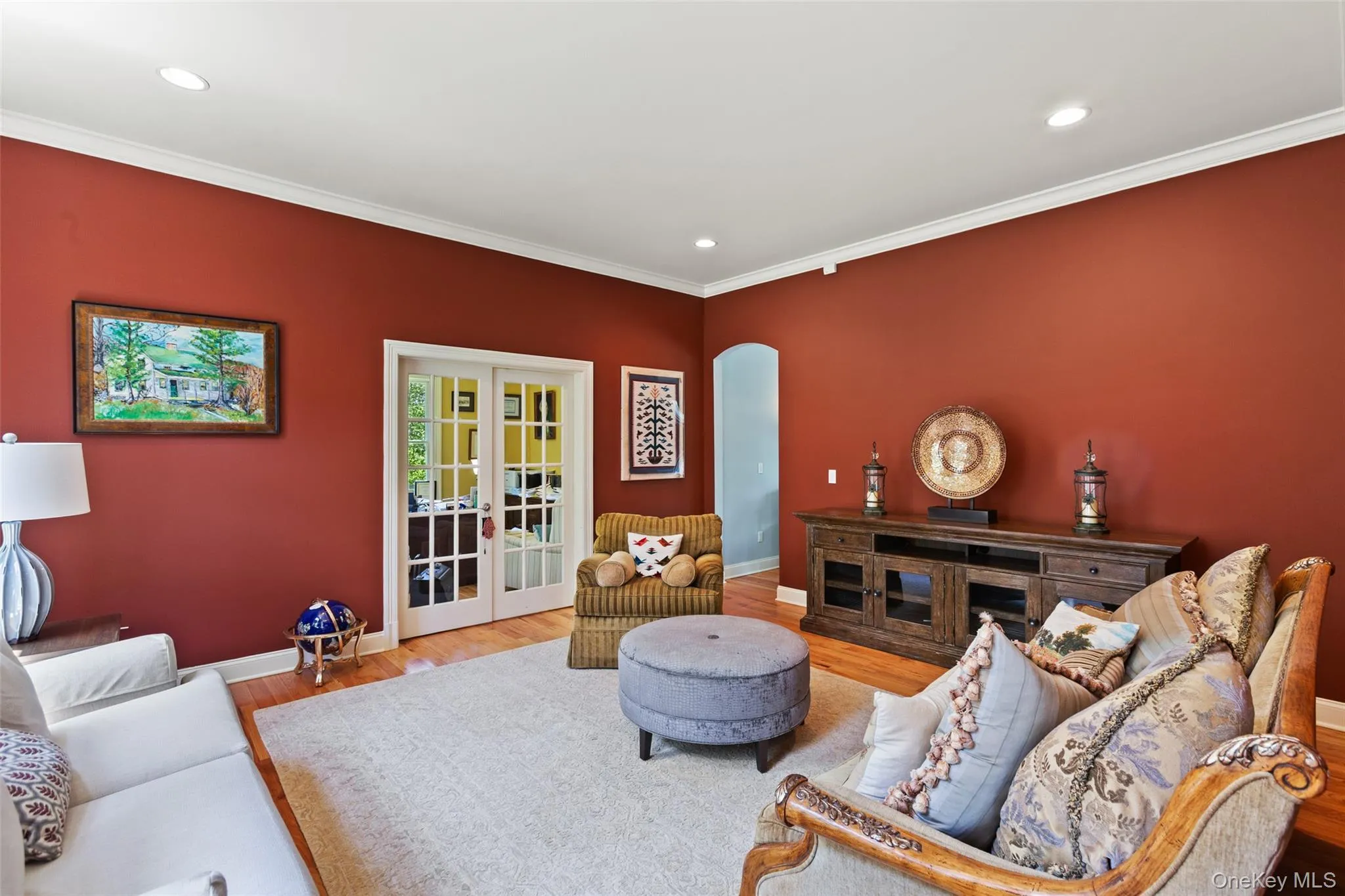 Living area with baseboards, wood finished floors, crown molding, french doors, and recessed lighting Living area with baseboards, wood finished floors, crown molding, french doors, and recessed lighting